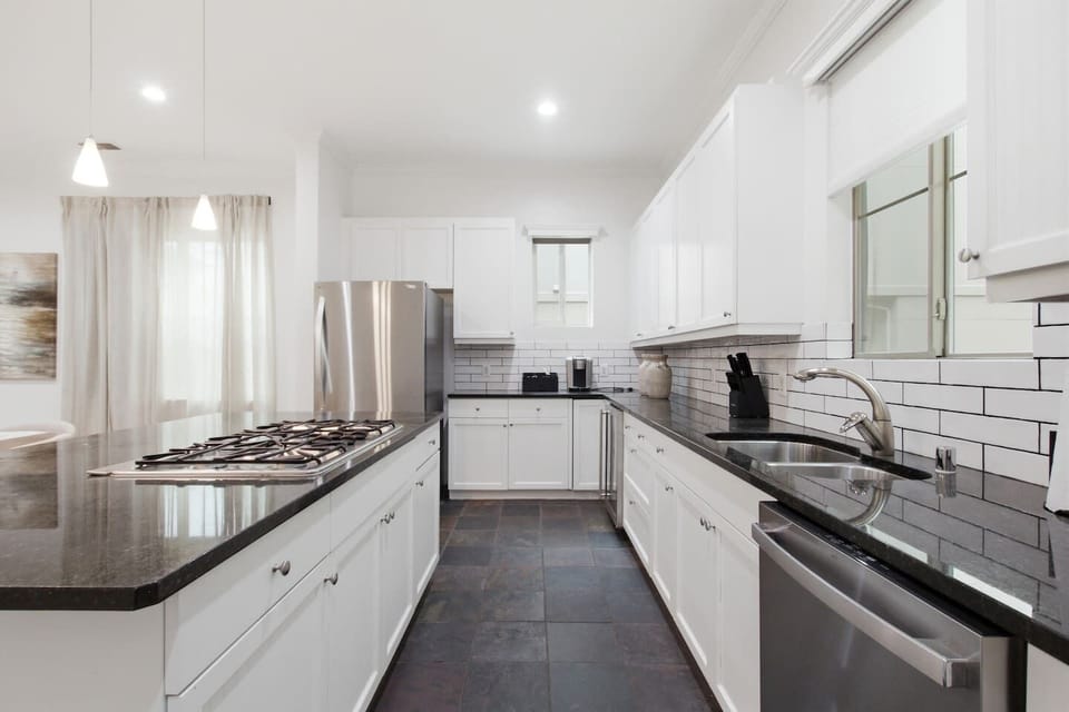 Gas cooktop with stainless range hood and full oven below. Fully outfitted with cookware and utensils for guests who want to cook in and skip the restaurant tab for a night.
