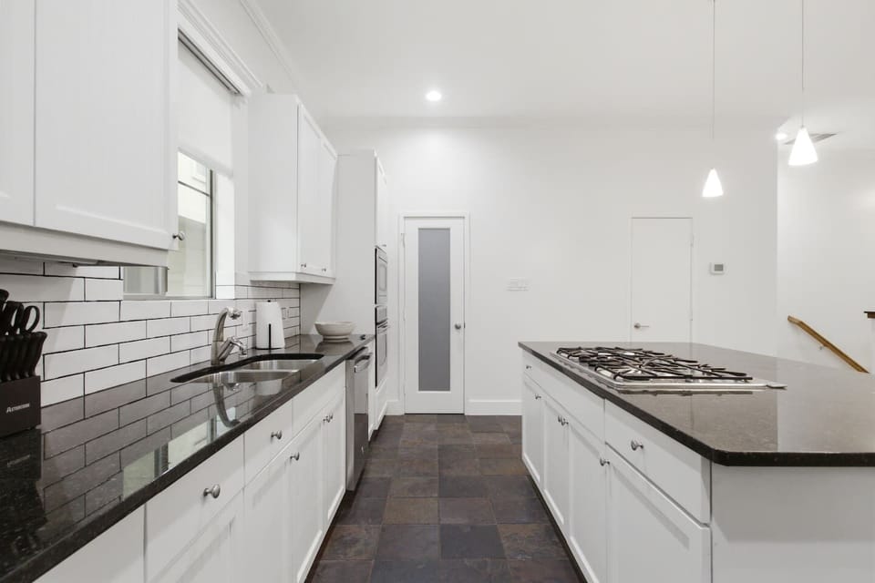 Generous counter space, white shaker cabinetry, and a classic subway tile backsplash. The kitchen is fully stocked and ready from the moment you arrive, no grocery run required.
