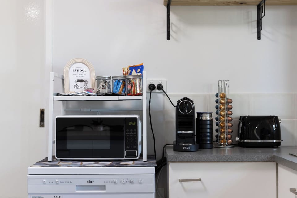 Modern kitchenette with Nespresso bar, snacks, toaster & microwave.