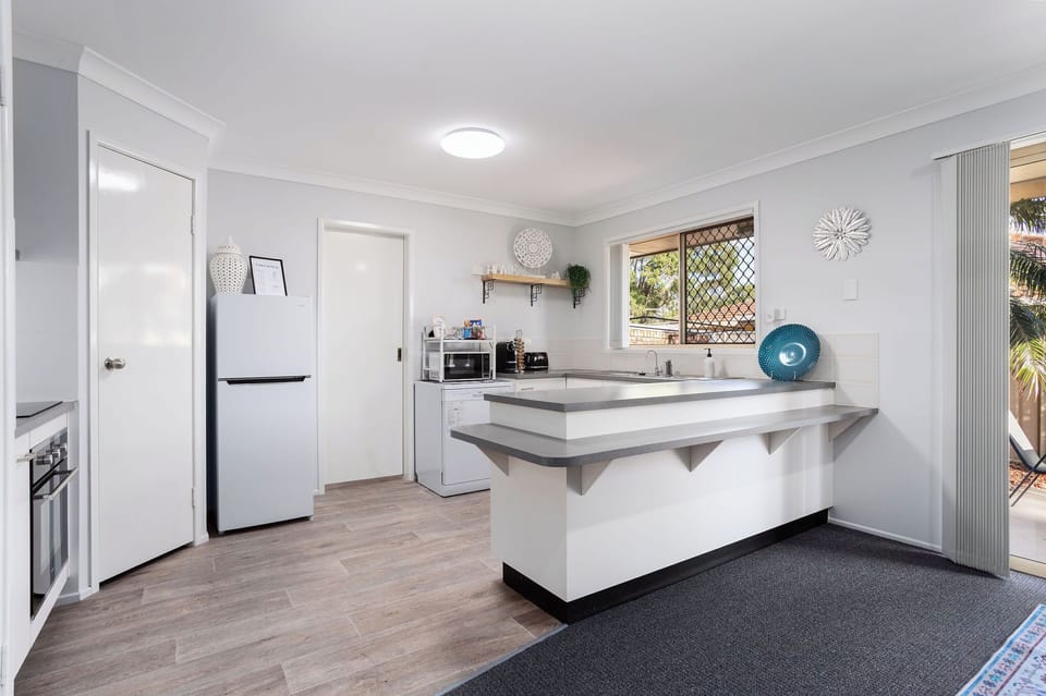 Bright kitchen with breakfast bar, patio access, and modern appliances