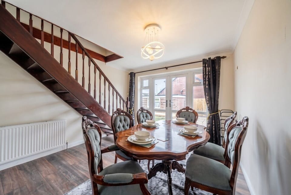 Gather around the elegant dining table set beneath the staircase