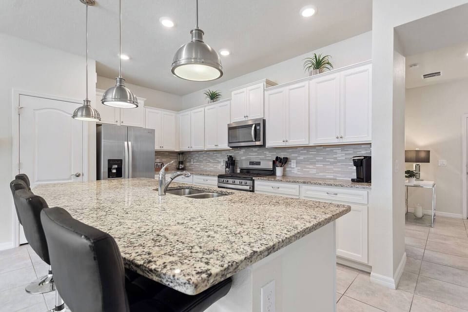 Stylish and functional kitchen featuring modern cabinetry, full-size appliances, and bright lighting—perfect for preparing family meals or entertaining during your stay.