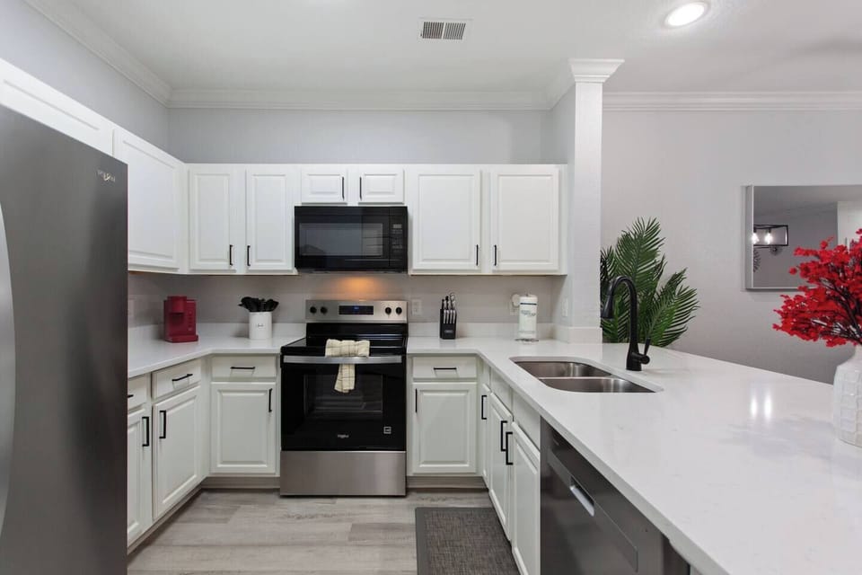Fully equipped kitchen featuring a new dishwasher, microwave, oven, and double sinks. Designed for convenience, it has everything you need to cook, clean, and enjoy meals with ease.