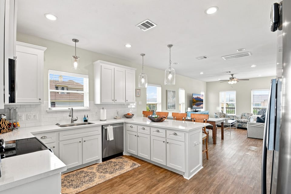 Bright open kitchen with island, dining space, and airy great room