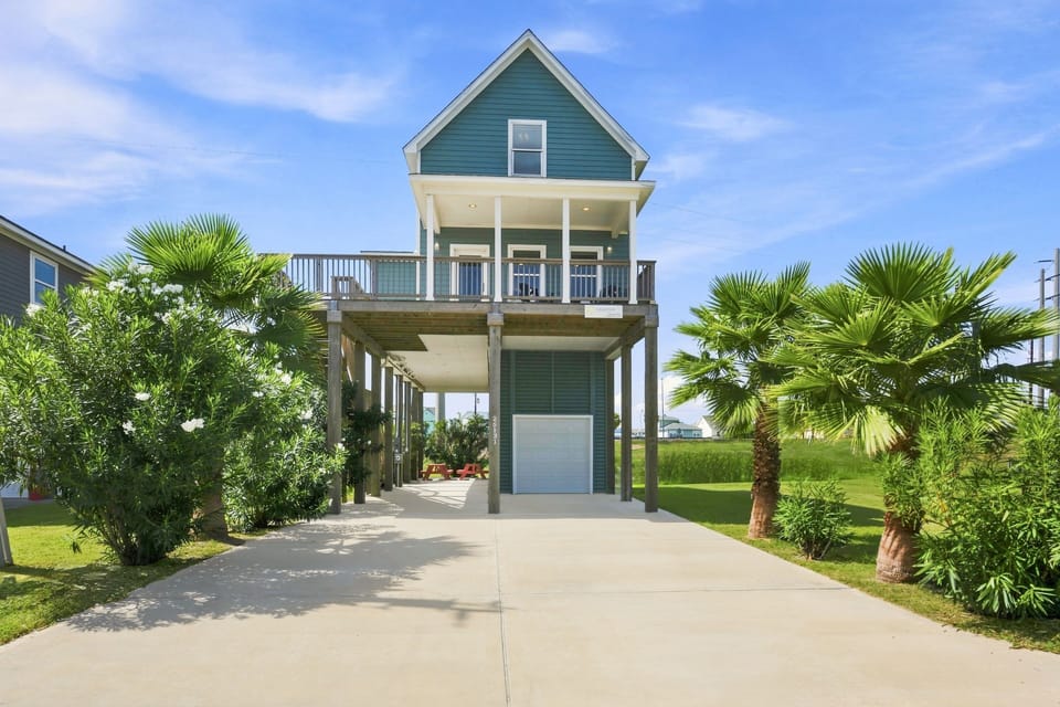 Charming elevated beach home with tropical landscaping and spacious deck
