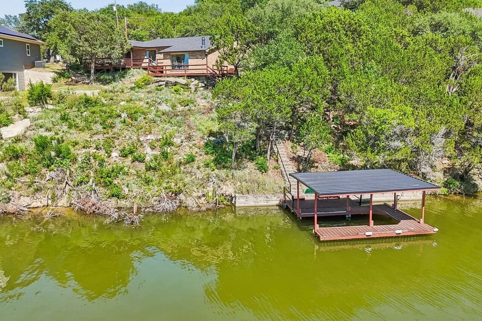 Aerial view showing the home, hillside, and covered dock.