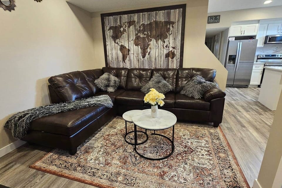 The living room features a comfortable sofa, a stylish coffee table, and an entertainment center with a 65" TV offering Netflix, Prime Video, YouTube, numerous channels, and more.
