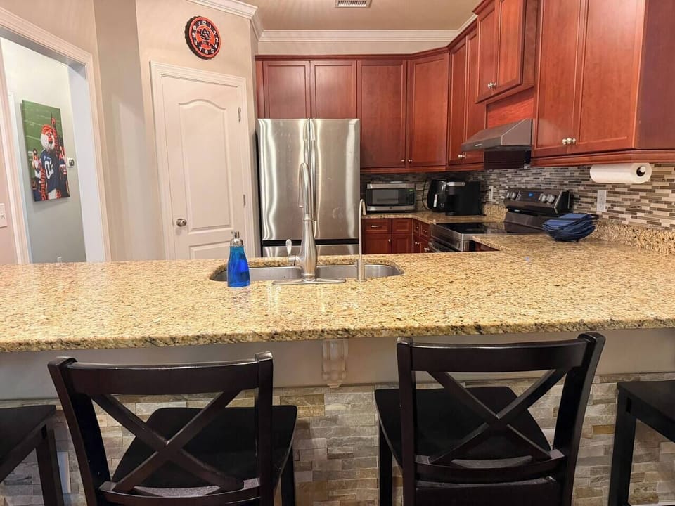 Cook up your favorite meals in this fully equipped kitchen! Features stainless steel appliances, granite countertops, a bar height seating area, and coffee maker—perfect for game day prep or slow morning breakfasts in Auburn! 