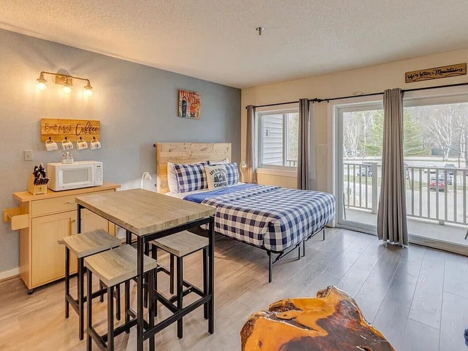 Queen bed and dining table beside the balcony door