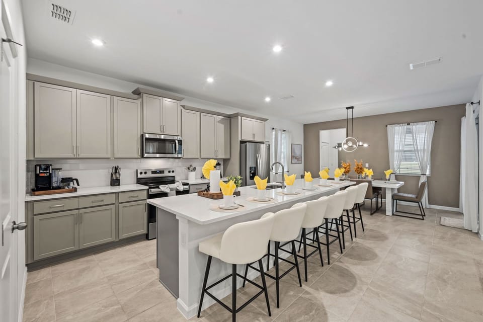 Cook and gather in this bright modern kitchen with sleek gray cabinets, stainless appliances, and a spacious island with plenty of seating for family meals.