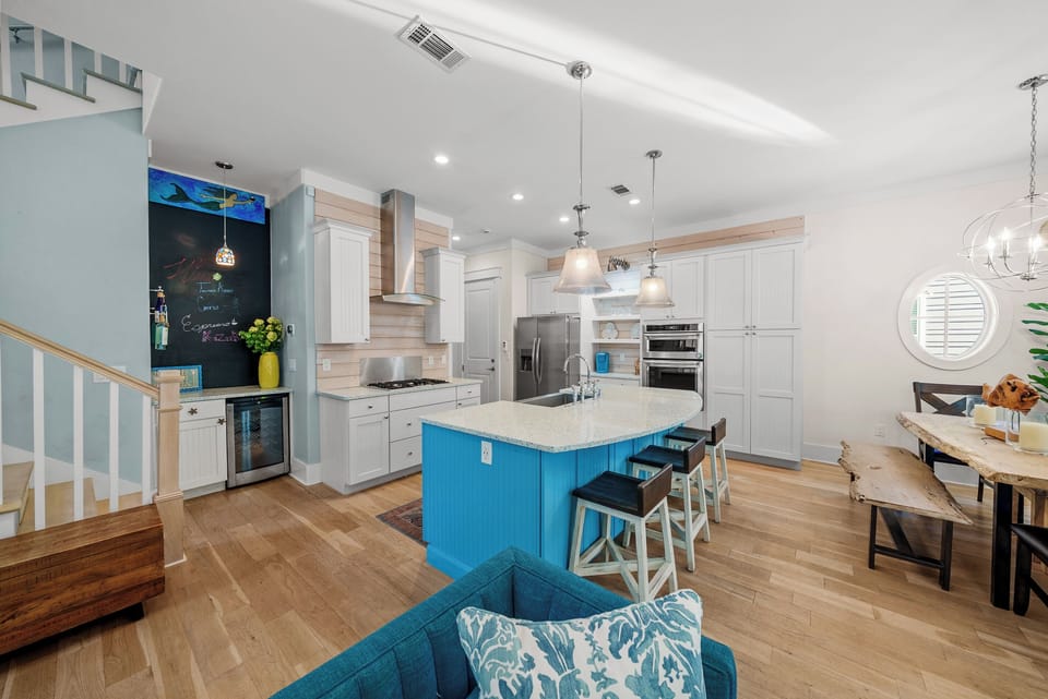 The main level runs from the island to the dining table to the sofa with no walls in between, and ten foot ceilings the whole way.