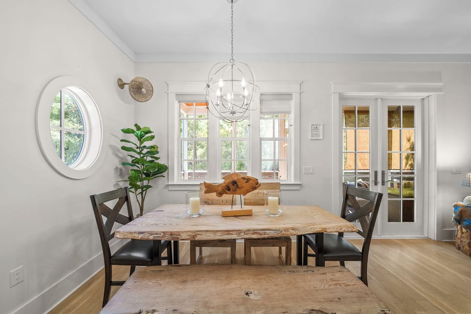 Gather six around the dining table under the chandelier, with the round porthole window throwing light across the room. Steps from the kitchen and the screened porch.