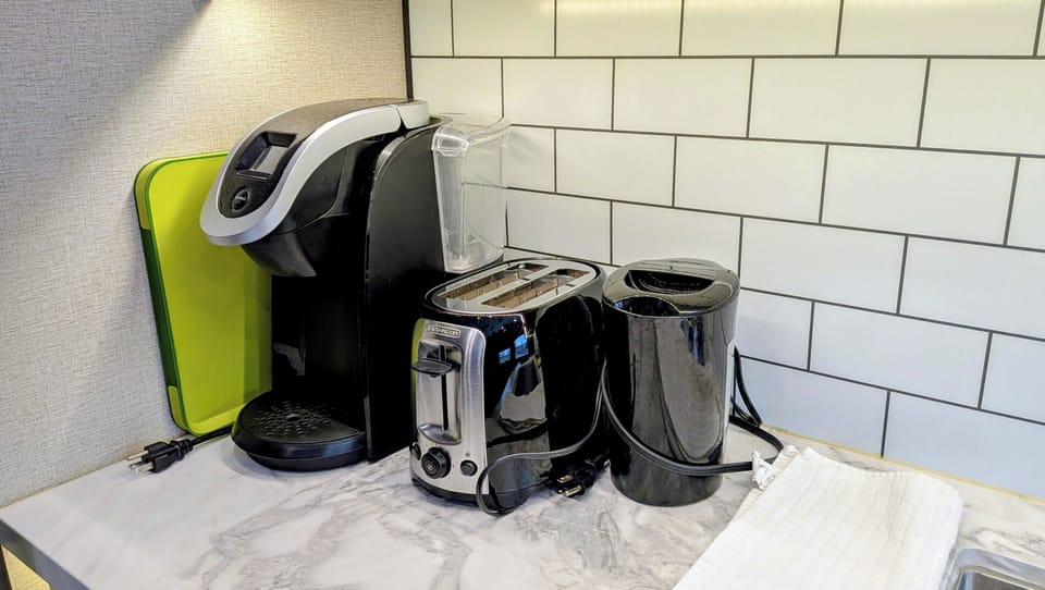 Coffee, tea & toast station with brewer, toaster, kettle on sleek counter