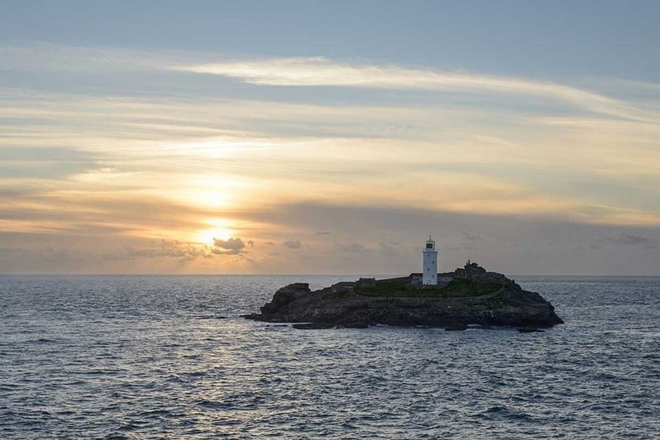 Sea view towards Godrevy lighthouse at sunset near Driftwood