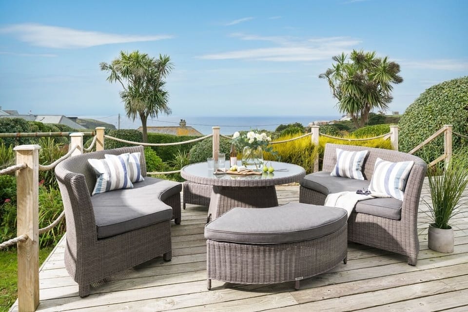 Sea views from the deck with garden furniture at Fourburrows in Mawgan Porth