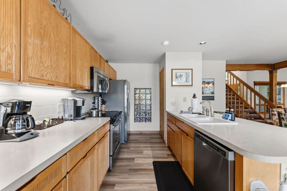 Open-concept fully equipped kitchen with 6 person dining table and bar seating