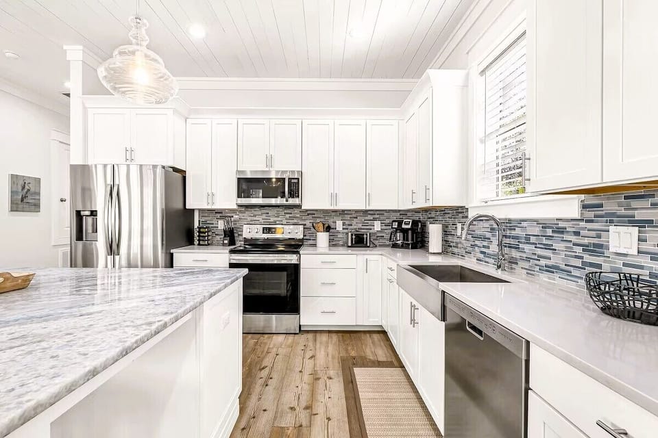 Kitchen Island: Spacious kitchen design boasting high-end culinary fixtures, and an oversized quartz island ideal for group meal preparation and casual morning coffee.