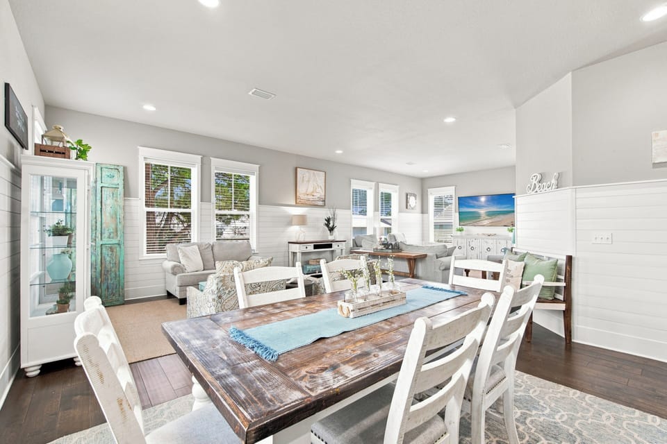 Gather around this rustic wooden dining table in your bright, beach-inspired space. Soft grays and whites create a relaxing coastal vibe, perfect for sharing meals and making memories.