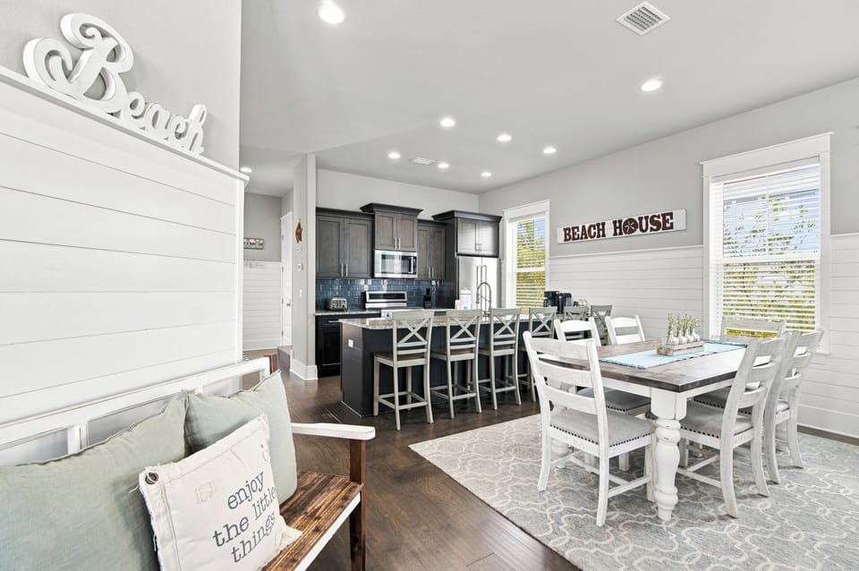 Step into your bright, coastal-inspired haven where shiplap walls and beach-themed accents set a relaxed tone. The open kitchen invites you to gather around the spacious island, while the dining table offers room for family meals and laughter.