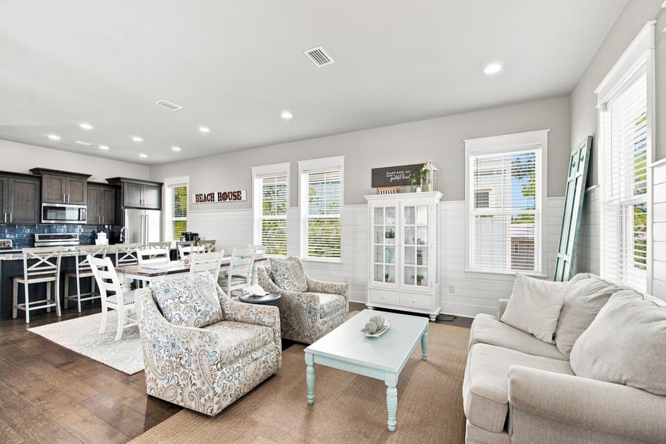 Unwind in your spacious open-concept living area with coastal charm and comfortable furnishings, perfect for gathering after beach days.