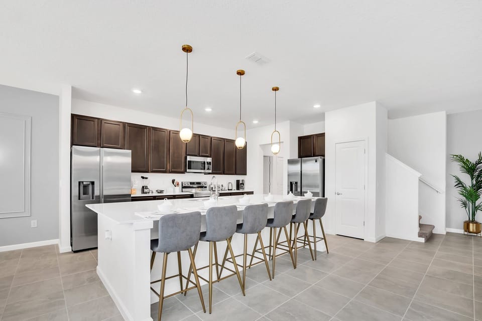 Spacious modern kitchen with sleek appliances and ample seating, perfect for entertaining large groups.