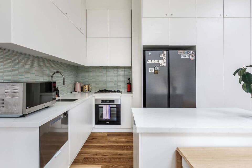 The kitchen features an oven, stovetop, microwave, dishwasher, toaster, kettle, a full-size fridge, and all cooking basics for easy meal preparation.