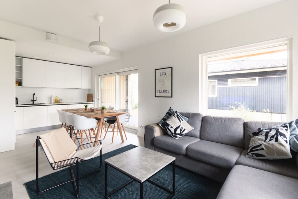 The living room has plenty of natural light and a large sofa for the whole group