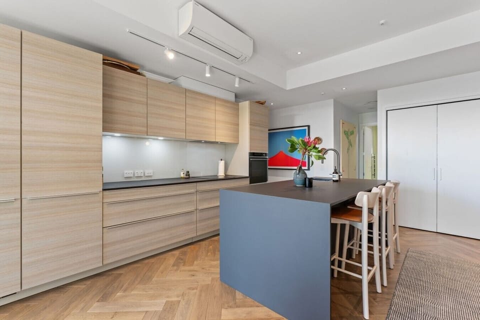 Sleek, fully equipped kitchen with generous bench space and breakfast-bar seating