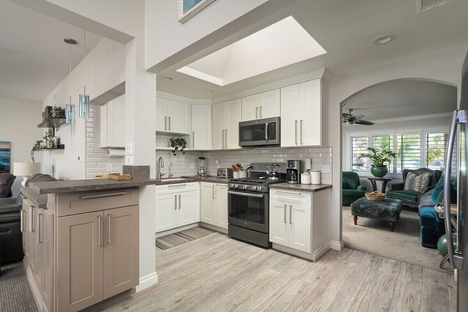 Kitchen | Open-concept kitchen with skylight, sleek cabinetry, and a view straight through to the living room.