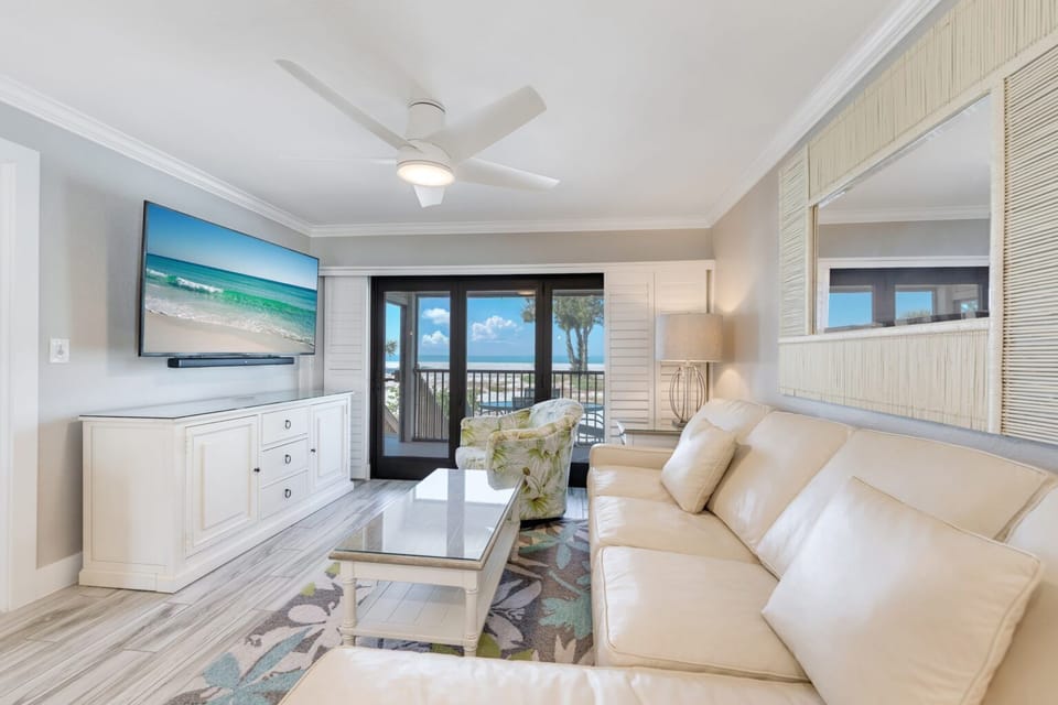 A spacious living area welcomes you with plush seating and panoramic views of the shimmering sea.