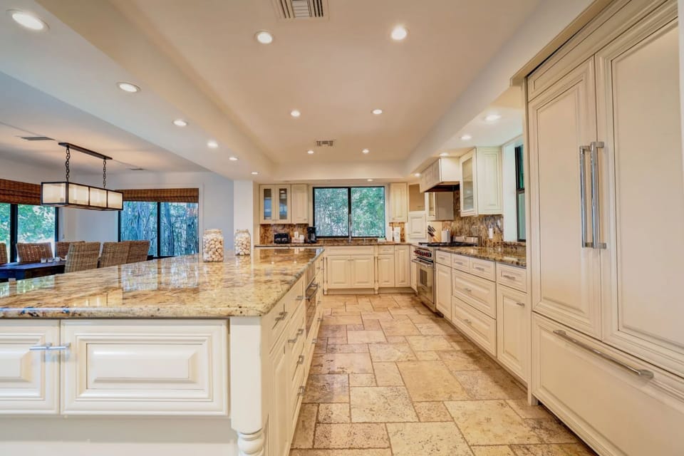 Gleaming surfaces and spacious counters define a chef's kitchen, where natural light brightens every culinary moment.