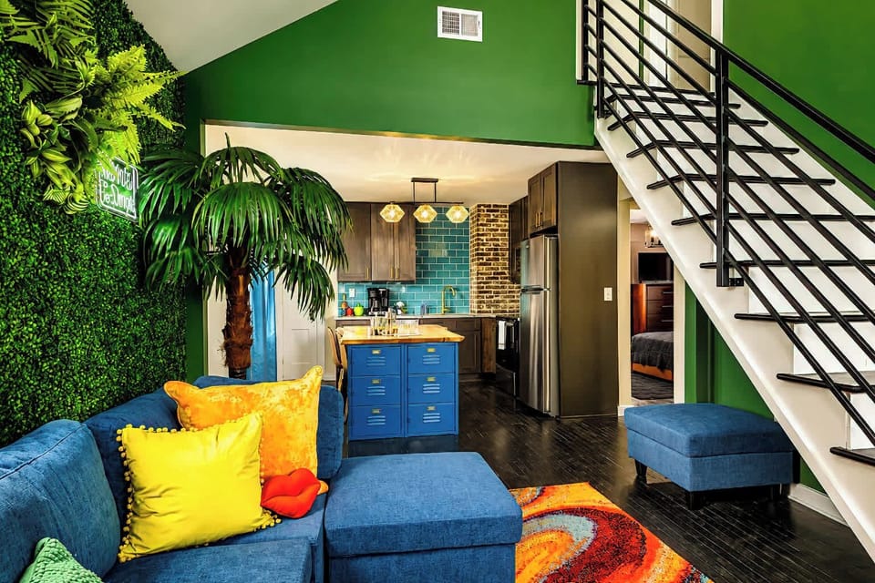 The living room brings the vibes with bright jungle accents, spacious seating and a Smart TV