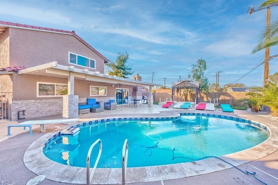 Private pool oasis with lounge chairs, shaded patio, and outdoor dining