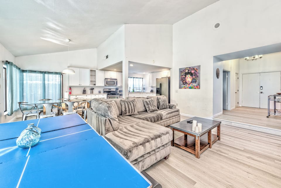 Bright open living space with high ceilings, full kitchen, and ping pong