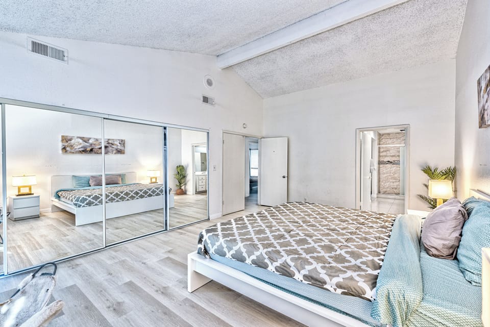 Bright, spacious bedroom with vaulted ceilings and mirrored closets
