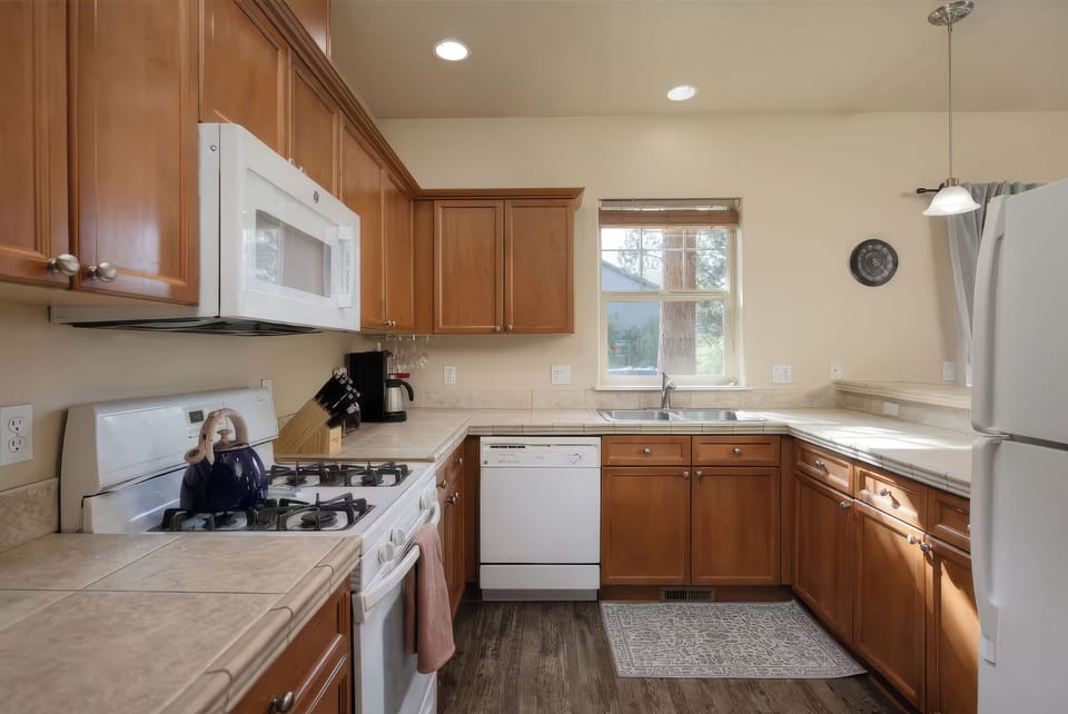 A fully equipped kitchen offers ample cabinet and counter space, with a gas range, dishwasher, and everything close at hand for easy meal prep.