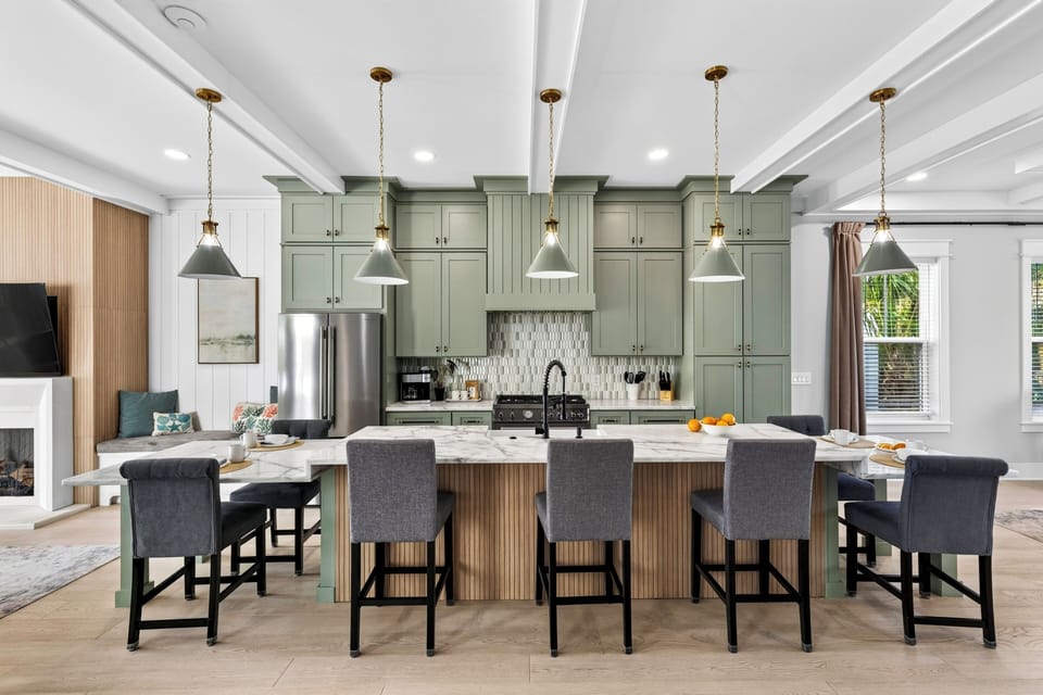 A spacious kitchen island with seating for six creates a natural gathering spot for casual meals, drinks, and conversation.