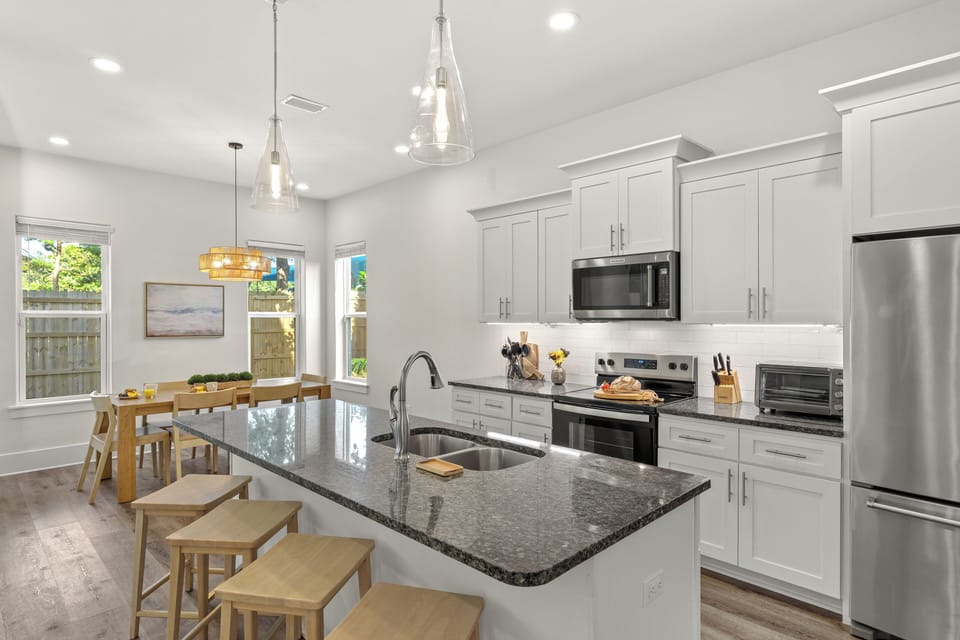 A sleek kitchen centers around a spacious island with seating for four, offering plenty of room for meal prep, casual bites, and conversation.