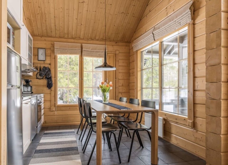 Open-plan kitchen and dining area with a large dining table by the windows.
