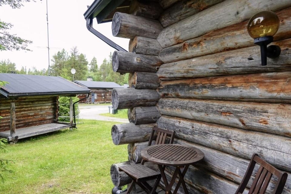 Yard seating with a table and chairs beside the log wall.