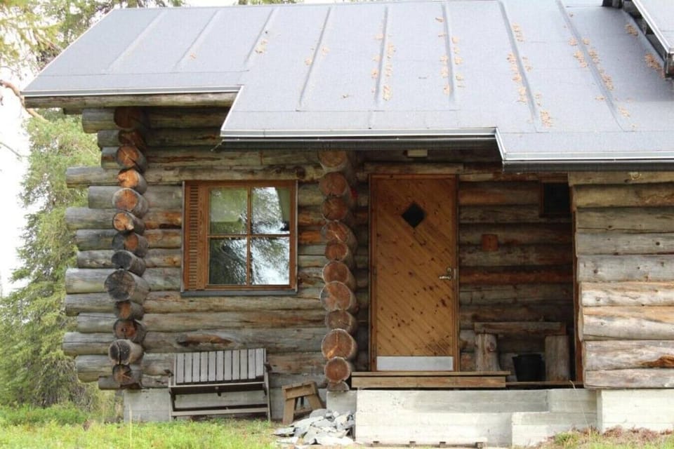 Traditional log facade with the private entrance and a bench beside the door.