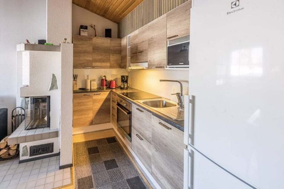 Fully equipped kitchen with an oven, stove, microwave, coffee maker and a fridge-freezer.