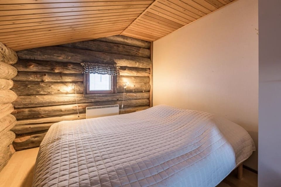 Loft sleeping area with a wide bed against the log wall.