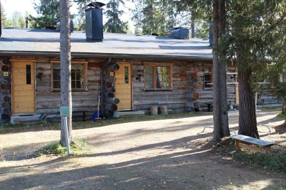 Long log facade of the terraced house with the entrances opening onto the yard.
