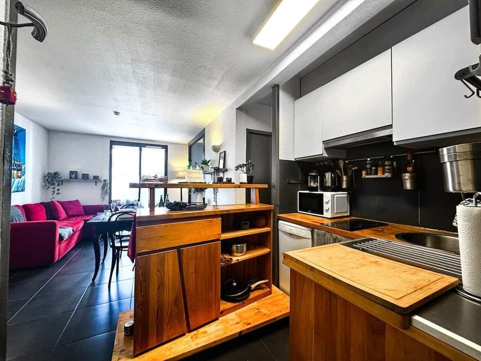 Dans la cuisine équipée, préparez vos plats préférés tout en restant connecté à l’ambiance chaleureuse du salon.