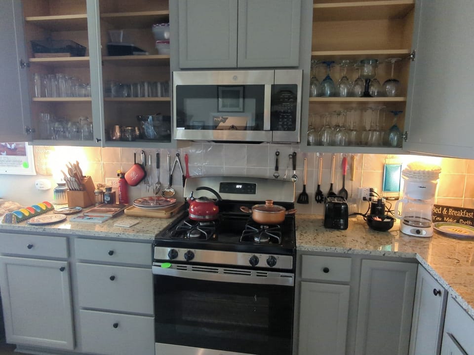Left side of kitchen. All glassware is in upper cabinets on either side.
