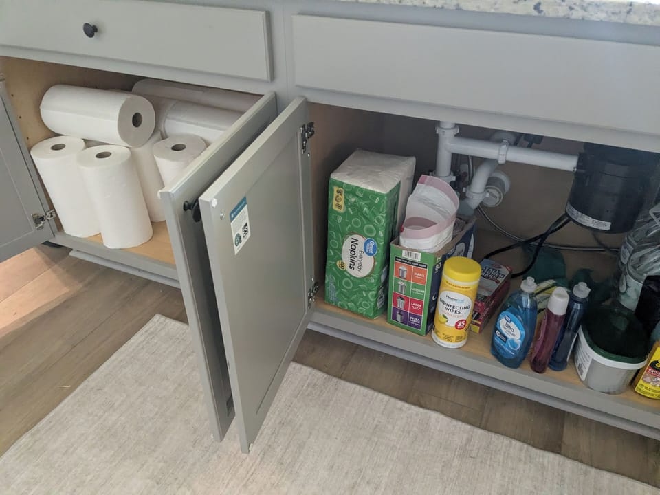 Kitchen island cabinetry, beneath sink.
