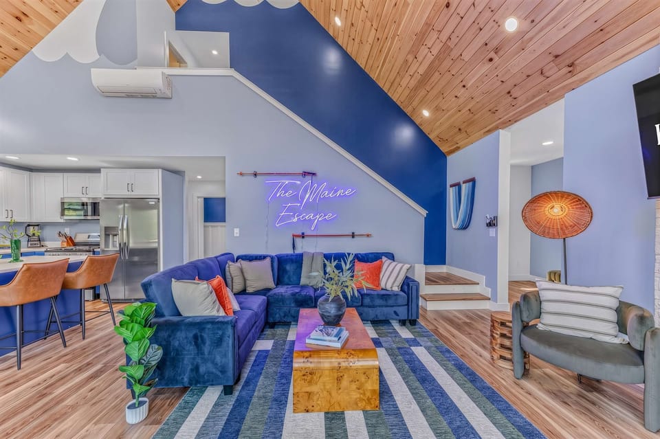 Sink into the plush blue sofas under vaulted wood ceilings for a living space that feels both cozy and elevated.
