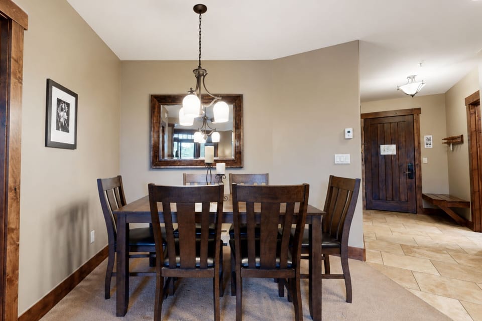Gather around the elegant dining table where warm wood tones and soft lighting create the perfect setting for your morning coffee or evening meals together.