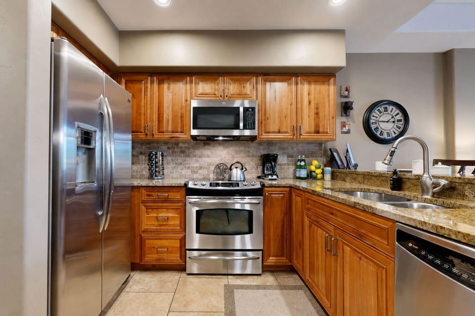 Cook your favorite meals in this fully equipped kitchen featuring stainless steel appliances, granite countertops, and warm wood cabinetry with ample storage for all your culinary adventures.